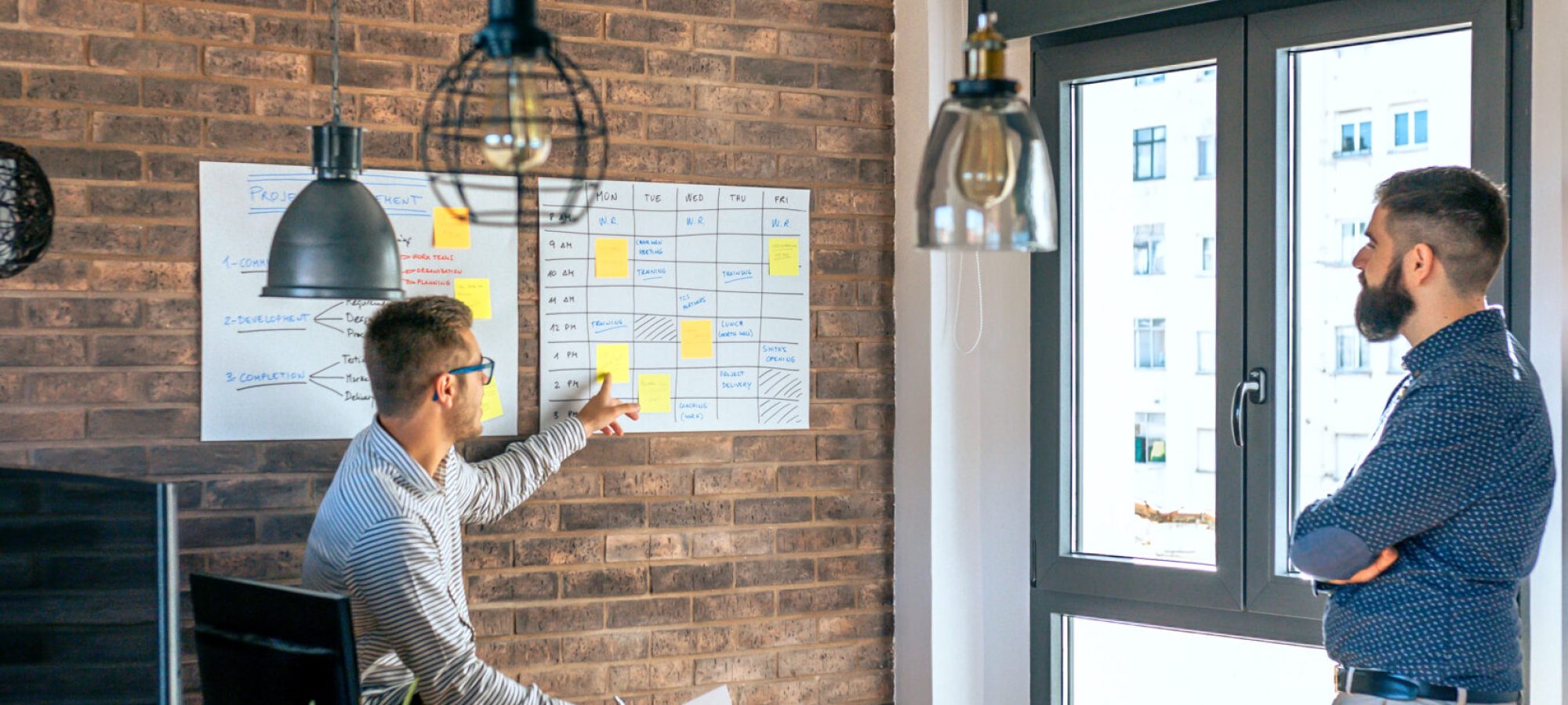 Young manager organizing work with a worker in an office